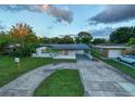 Inviting exterior view of home with circular driveway and covered parking at 3947 Overlook Ne Dr, St Petersburg, FL 33703