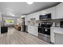 Open-concept kitchen and living area with stainless steel appliances and comfortable leather seating at 4218 E Cayuga St, Tampa, FL 33610