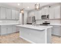 Modern kitchen featuring stainless steel appliances, an island, and ample cabinet space at 4262 Cloud Hopper Way, Lutz, FL 33559