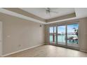 Bright living room with waterfront views from the large sliding doors and elegant tray ceiling with fan at 530 S Gulfview Blvd # 203, Clearwater Beach, FL 33767