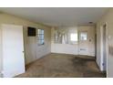 The living room features a vintage chandelier, carpet, a doorway, and two windows at 5707 S 79Th St, Tampa, FL 33619