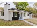 Charming home with a brick facade and white accents, complemented by a chimney and a well-manicured front lawn at 5801 N 17Th St, Tampa, FL 33610