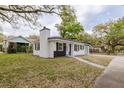 A charming home with a well-kept lawn, a black-and-white exterior, and a quaint chimney at 5801 N 17Th St, Tampa, FL 33610