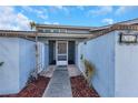 Inviting entryway with brick accents and a decorative metal gate leading to the front door at 605 Citrus Ct, Largo, FL 33770