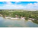 Beautiful aerial view of the coastline featuring a sandy beach and lush vegetation at 611 Shore E Dr, Oldsmar, FL 34677