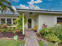 Welcoming front entrance with a tiled walkway, charming landscaping, and a cozy yellow chair at 6202 7Th S Ave, Gulfport, FL 33707