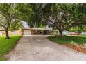 Single-story home with a large front yard, mature trees, long driveway, and neutral colored exterior at 6635 9Th N Ave, St Petersburg, FL 33710