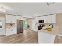 Bright, modern kitchen with white cabinets, stainless appliances, and view to a backyard pool at 704 Childers Loop, Brandon, FL 33511