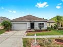 Charming single-story home with a well-maintained lawn, fresh landscaping, and a two-car garage at 7611 Wood Violet Dr, Gibsonton, FL 33534