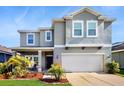 Well-maintained two-story home with a manicured lawn, landscaping, and an attached two-car garage at 8111 Brickleton Woods Ave, Gibsonton, FL 33534
