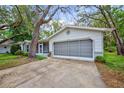Charming single-story home with well-manicured lawn, mature trees, and a covered front entry at 8619 Gold Pine Dr, Port Richey, FL 34668