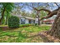 Inviting single-story home with lush green lawn, mature trees, and well-maintained landscaping at 8619 Gold Pine Dr, Port Richey, FL 34668