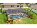 Beautiful backyard with screened pool, lounge chairs, and tropical landscaping, perfect for relaxation at 9136 Warm Springs Cir, Parrish, FL 34219