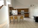 A kitchen with tile floors, breakfast bar with seating, and wooden cabinets at 10402 Ashley Oaks Drive, Riverview, FL 33578