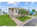 Attractive manufactured home featuring a tidy lawn, a covered parking space, and a welcoming entryway at 12501 Ulmerton Rd # 110, Largo, FL 33774