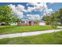 Charming brick home with a well-manicured lawn, lush trees, and a two-car garage at 13296 88Th N Ave, Seminole, FL 33776
