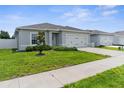 Well-manicured front lawn and a charming gray home with a two-car garage enhance the curb appeal of this property at 14532 Whitewater Way, Brooksville, FL 34604