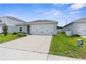 Modern home with a two-car garage, complemented by a green lawn and a concrete driveway for curb appeal at 14532 Whitewater Way, Brooksville, FL 34604