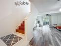 Entryway with wood floors leading to a staircase and living area with sliding glass doors at 147 114Th Ne Ave # 147, St Petersburg, FL 33716