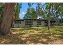 A charming single story home with light colored siding is surrounded by a lush green lawn at 1501 Howard Pl, Largo, FL 33770
