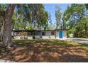Single-story home with a pop of color from its vibrant blue door and freshly manicured lawn at 1501 Howard Pl, Largo, FL 33770