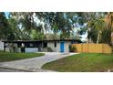 Charming single-story home boasts a blue door, a well-manicured lawn, and a private fenced yard at 1501 Howard Pl, Largo, FL 33770