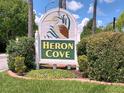 An attractive Heron Cove community sign surrounded by lush landscaping in a well-maintained entrance area at 1605 Send Way, Lutz, FL 33549