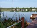 Scenic lake view from the dock with bench, vegetation and distant houses at 1605 Send Way, Lutz, FL 33549