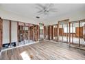 Open-concept living room showcasing wood-look flooring and exposed wall studs at 1841 Douglas Ave, Dunedin, FL 34698