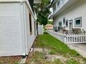 Green grass side yard and a partial view of a white picket fence create a serene and private outdoor space at 20989 Negril, Lutz, FL 33558