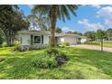 Landscaped home exterior featuring a lush green lawn and mature palm tree at 2222 Westchester Blvd, Spring Hill, FL 34606