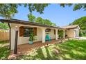 Charming one-story home featuring a brown two-car garage, well-maintained lawn, and inviting front porch area at 2329 Carrie Ct, Dunedin, FL 34698