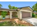 Charming one-story home with a two-car garage, a sidewalk leading up to the front door, and a well-maintained lawn at 2329 Carrie Ct, Dunedin, FL 34698