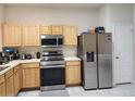 Functional kitchen with stainless steel appliances and light wood cabinetry at 26541 Chimney Spire Ln, Wesley Chapel, FL 33544
