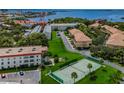 Stunning aerial view of the condo community featuring tennis courts, mature trees and water views at 2700 Bayshore Blvd # 5307, Dunedin, FL 34698