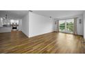 Bright living room featuring wood-look flooring and large windows with decorative sconces at 2700 Bayshore Blvd # 5307, Dunedin, FL 34698