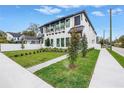 Stylish two-story home with a modern exterior, complemented by lush landscaping and a brick walkway at 2812 N Massachusetts Ave, Tampa, FL 33602