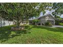 Beautifully landscaped front yard with lush green grass and a mature tree providing ample shade at 3115 Westridge Dr, Holiday, FL 34691