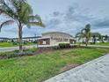 Stone monument sign for Watergrass Towns community, landscaped with palms and green grass at 32451 Limitless Pl, Wesley Chapel, FL 33545