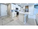 A modern kitchen with white cabinetry, stainless steel appliances, and an island with a sink at 32451 Limitless Pl, Wesley Chapel, FL 33545