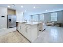 Bright kitchen with island, stainless steel appliances, and an open-concept layout into the living area at 32451 Limitless Pl, Wesley Chapel, FL 33545