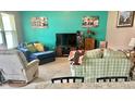 Comfortable living room with a teal accent wall, large TV, plush seating, and lots of natural light at 3313 San Moise Pl, Plant City, FL 33567