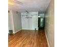 Open-concept living room with wood-look floors, neutral walls, and minimalist shelving for modern decor at 4020 55Th N St # 1106, Kenneth City, FL 33709