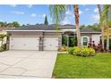 Charming single-story home featuring a three-car garage, lush landscaping, and a welcoming entryway at 4505 Anaconda Dr, New Port Richey, FL 34655