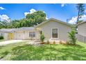 Cozy one-story home with an attached garage, neatly landscaped yard, and a welcoming modern entrance at 4605 W Loughman St, Tampa, FL 33616