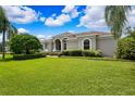 Well-manicured front lawn, lush landscaping, and a stately entrance highlight this home's curb appeal at 5904 Pelican Bay S Plz, Gulfport, FL 33707