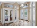 Inviting foyer with decorative doors, travertine floors, and transom windows for lots of natural light at 5904 Pelican Bay S Plz, Gulfport, FL 33707