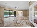 Spacious living room with travertine floors and access to the pool area through sliding glass doors at 5904 Pelican Bay S Plz, Gulfport, FL 33707