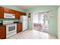 Bright kitchen featuring white appliances, tile floors, and sliding glass doors to the lanai at 6336 Bayside Key Dr, Tampa, FL 33615
