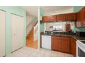 Spacious kitchen boasting wooden cabinets and white appliances adjacent to stairs at 6336 Bayside Key Dr, Tampa, FL 33615
